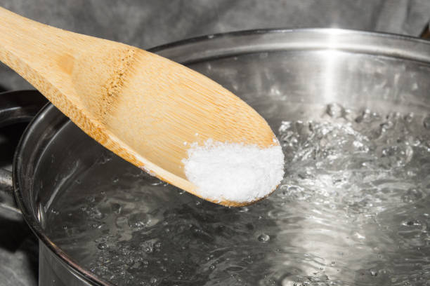 istock In boiling water pour salt with a wooden spoon. 1008059710