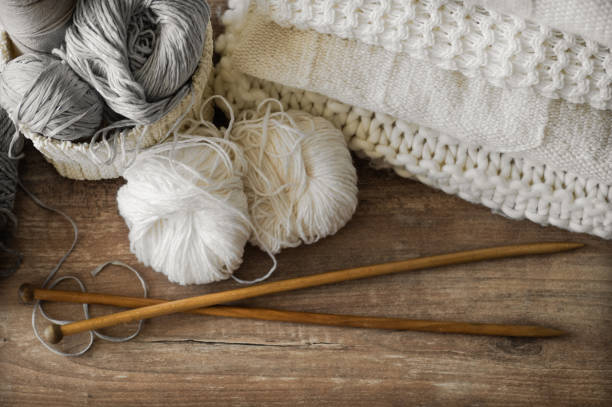 istock A woven basket with white and gray thread for knitting and knitting needles. White sweaters and yarn for knitting closeup. Winter 1008085662