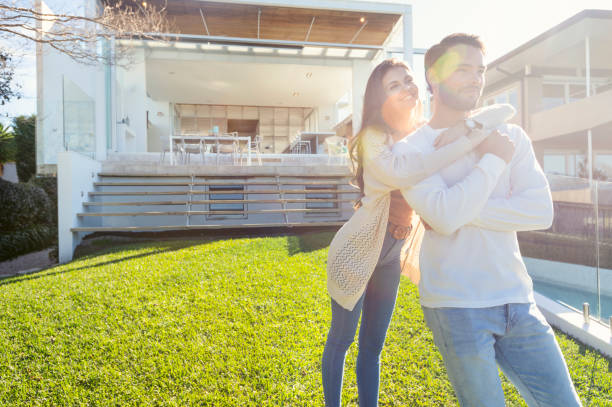 istock Young Couple standing in front of a modern new house. 1008090678