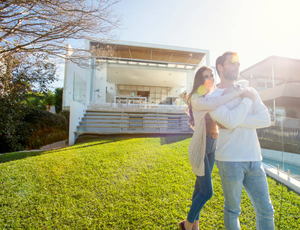 istock Young Couple standing in front of a modern new house. 1008090696