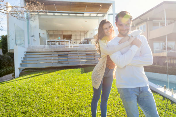 istock Young Couple standing in front of a modern new house. 1008090868
