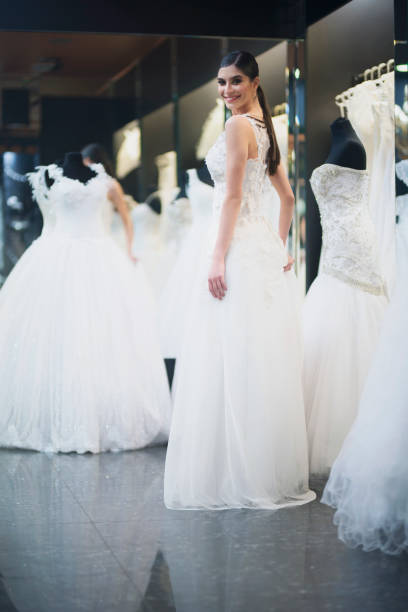 istock Adorable bride trying on wedding dress 1008104866