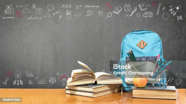 Back To School Concept With School Books Textbooks Backpack And Stationery Supplies On Classroom Desk With Teachers Black Chalkboard Background With Educational Doodle For New Academic Year Begin Stock Photo - Download Image Now