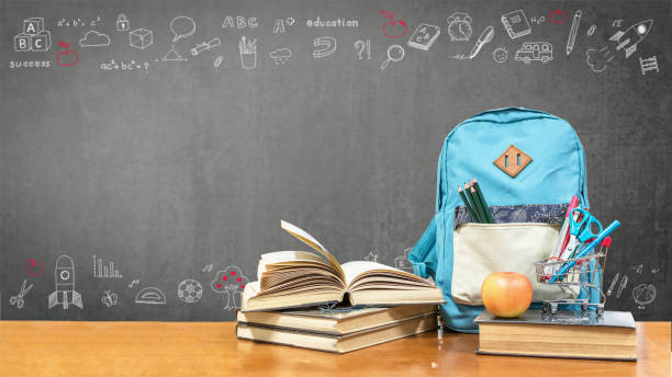 back to school concept with school books, textbooks, backpack and stationery supplies on classroom desk with teacher's black chalkboard background with educational doodle for new academic year begin - blackboard education classroom photography imagens e fotografias de stock