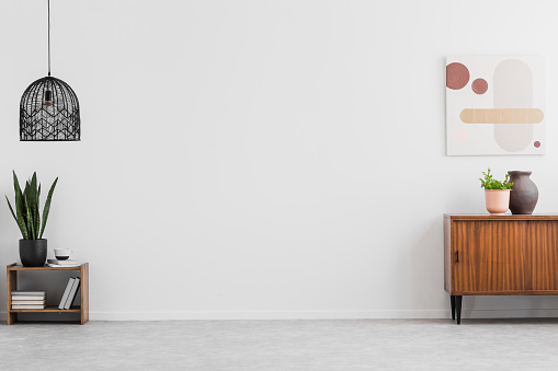 Retro, gabinete de madera y una pintura en un salón vacío interior con paredes blancas y copia espacio para un sofá. Foto real. photo