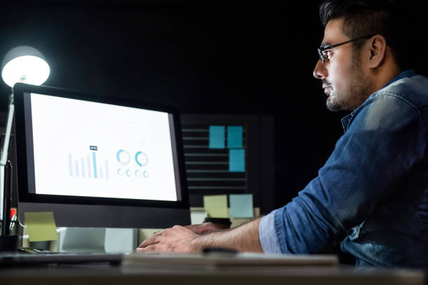 istock Workaholic man working overtime late at night in the office 1008108162
