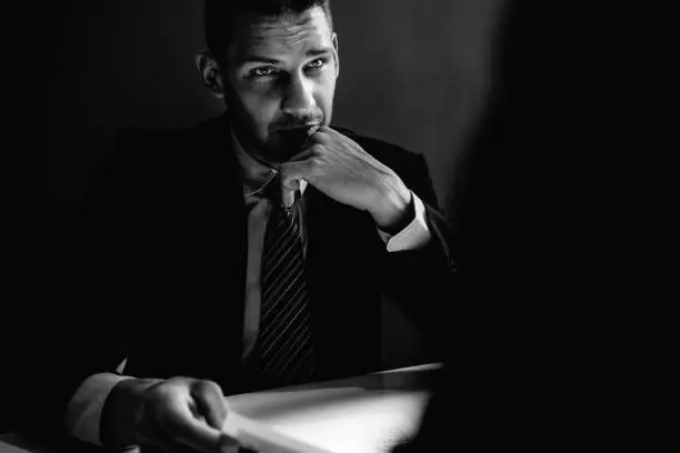 Detective interview suspect or criminal man in interrogation room in black and white tone