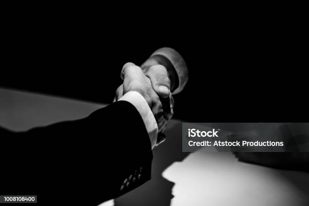 Anonymous Business Partners Making Handshake In Shadow Stock Photo - Download Image Now