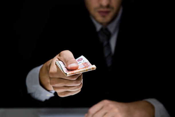 istock Businessman giving bribe money in dark shadow 1008108436