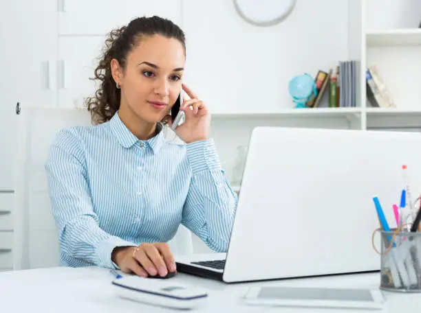 Portrait of businesswoman talking on mobile phone in modern office