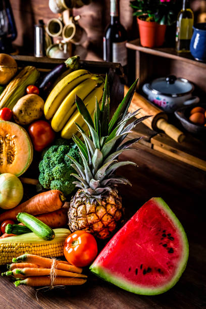 istock Assorted organic tropical fruits and vegetables in a rustic kitchen background. Natural lighting 1008132496