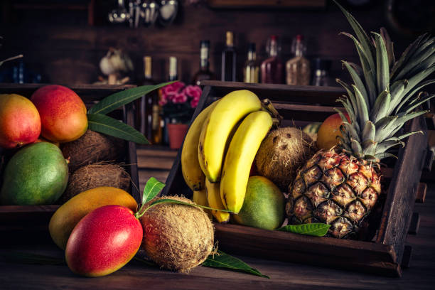 Wooden crates with assorted tropical fruits in rustic kitchen. Natural lighting