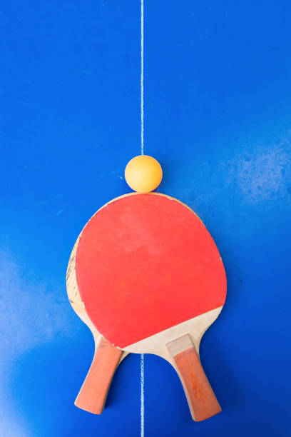 istock pair of old pingpong rackets and a ball on a blue pingpong table 1008149492