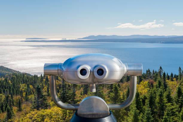 Public binoculars in front of a view over the Forillon National Park, Gaspe Peninsula, Quebec, Canada (montage) Public binoculars in front of a view over the Forillon National Park, Gaspe Peninsula, Quebec, Canada (montage) forillon national park stock pictures, royalty-free photos & images