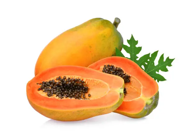 whole and half of ripe papaya fruit with green leaf isolated on white background