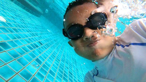 Asian Muslim Children Swimming in an Apartment Swimming Pool