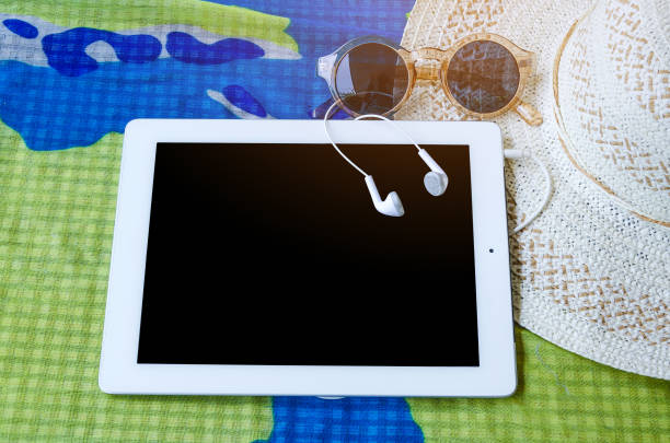 istock sunglasses with laptop computer and white hat, summer traver concept. 1008194552