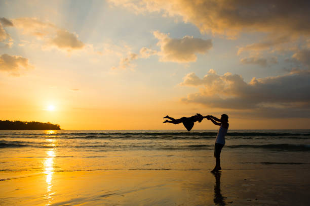 istock Father and daughter play on sunset beach 1008199478