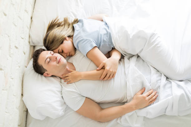 пара, имеющих сон вместе на кровати у себя дома - couple affectionate relaxation high angle view стоковые фото и изображения