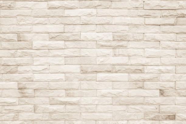 istock Cream and white brick wall texture background. Brickwork or stonework flooring interior rock old pattern clean concrete grid uneven bricks design stack. 1008202318