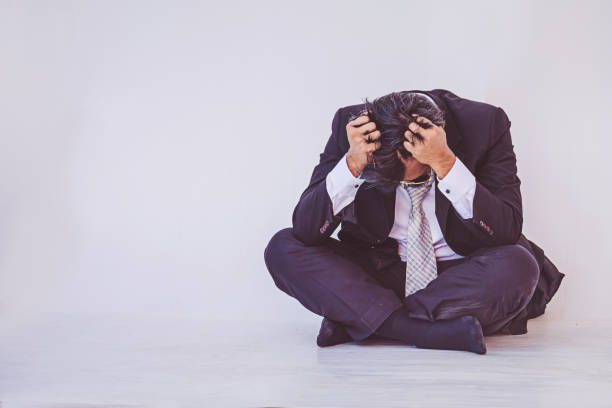 istock Depressed businessman sitting on the floor 1008204574