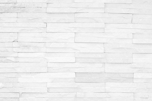 Grey and white brick wall texture background. Brickwork or stonework flooring interior rock old pattern clean concrete grid uneven bricks design stack.