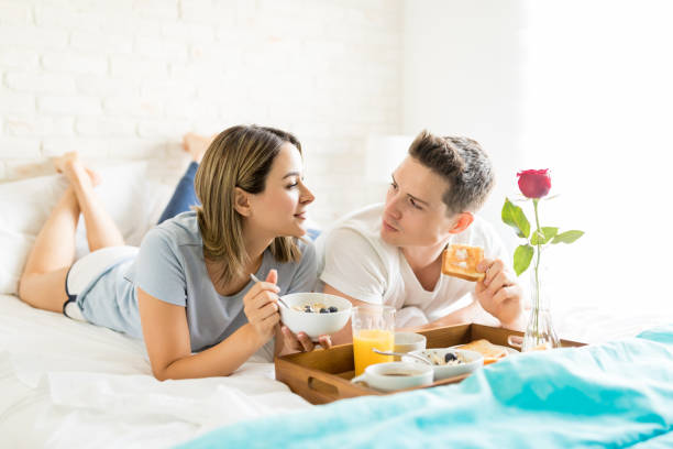 istock Man And Woman Talking While Having Food By Breakfast Tray 1008204736