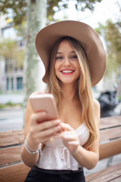 istock Cheerful positive young lady with smartphone smiling at camera 1008204940