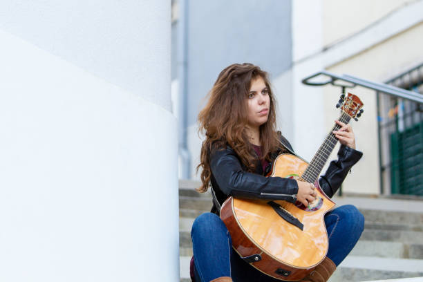 istock Pensive female guitarist testing new instrument 1008207640