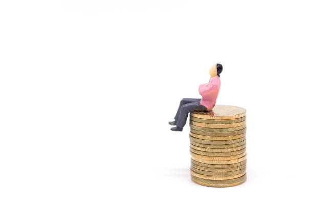 istock Miniature businessman and coins on white background 1008209756