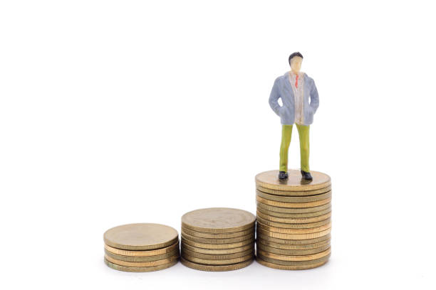 istock Miniature businessman and coins on white background 1008209760