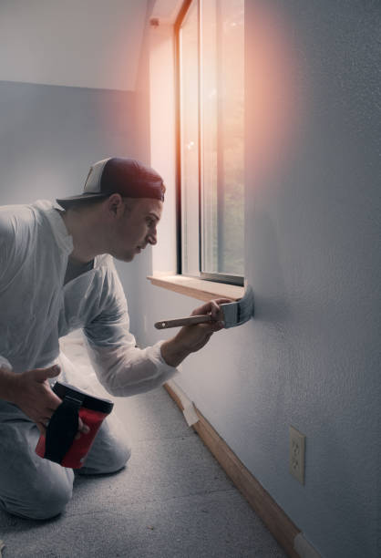 istock Man painting interior of home by window 1008212998