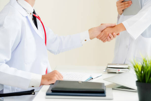 istock Doctor at hospital shakes hand with another doctor 1008215744