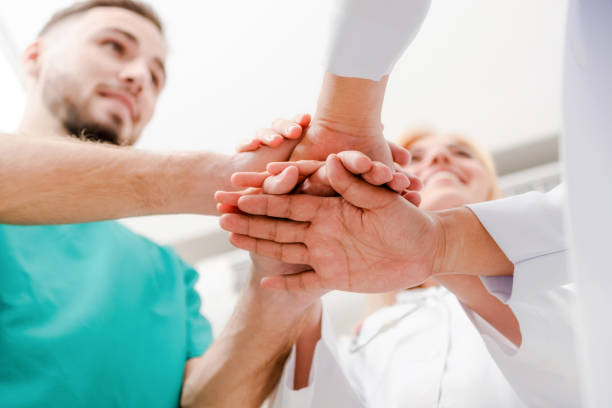 istock Doctor, surgeon and nurse join hands together. 1008215746
