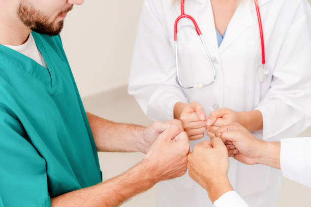 istock Doctor, surgeon and nurse join hands together. 1008215752