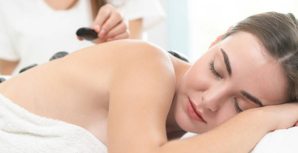 istock Hot stone massage treatment by therapist in spa. 1008223102