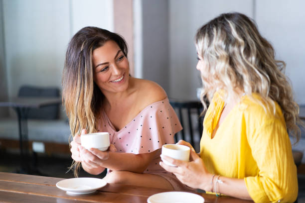 istock Smiling women having fun and drinking coffee in cafe 1008223544
