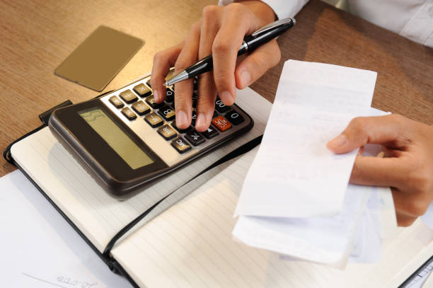 istock Closeup of person holding bills and calculating them 1008226444