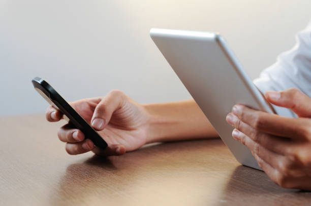 istock Closeup of person working on tablet computer and smartphone 1008226560