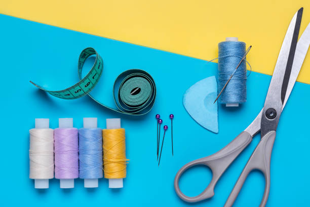 istock Scissors, set of sewing needles and bright colored threads on reels. 1008231558