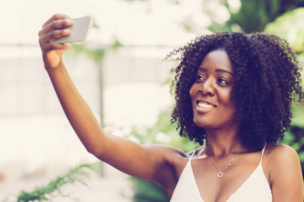 istock Smiling Black Lady Taking Selfie Photo in Park 1008234806