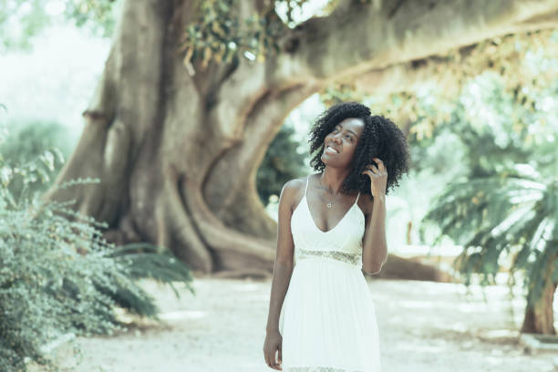 istock Smiling Dreamy Black Woman Walking in Park 1008234846