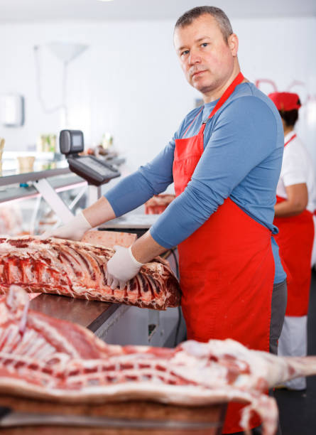 istock Glad man splitting and showing of pig carcass 1008237734