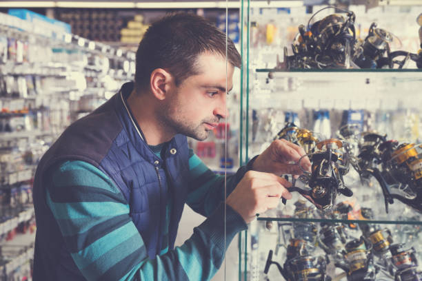 istock Fisherman customer choosing new baitcasting reel 1008238108