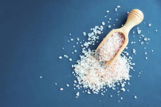 Himalayan pink salt in crystals above a gray stone