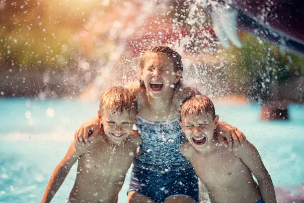 Kids having fun in pool in a waterpark. Laughing and screaming after being splashed with bucket of cold water.
Nikon D850