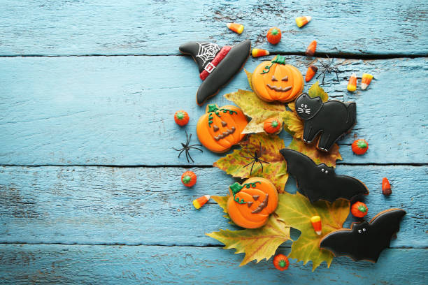 istock Halloween gingerbread cookies with candies on blue wooden table 1008253654