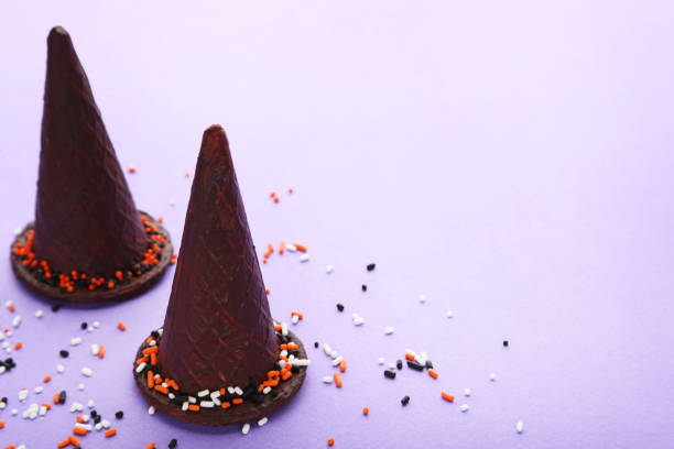 istock Chocolate halloween hats on purple background 1008254480