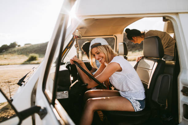 istock Smiling woman driving mini van during the road trip 1008257258