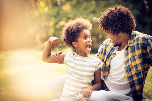 Smiling happy day in nature. African American father and daughter playing in nature. man laughing hard stock pictures, royalty-free photos & images